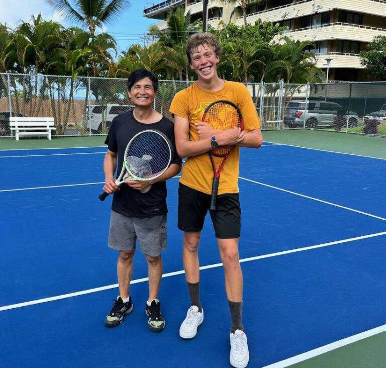 Tony and Austin holding rackets on a blue court in Kona, Hawaii